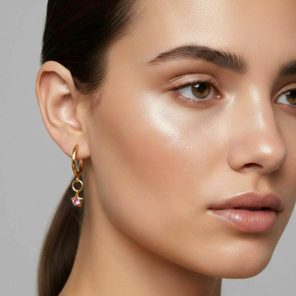 Modelo llevando los Aros Aura de Algo de Olga — pendientes de aro dorado con estrella y cristal rosa puestos