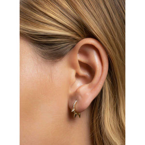 Aros mini dorados con circonitas y pinchos puestos en una modelo.