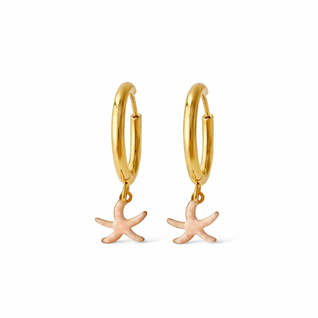 Aros de acero dorado con colgante de estrella de mar esmaltada en rosa con pintitas blancas sobre fondo blanco. Pendientes de acero Algo de Olga.