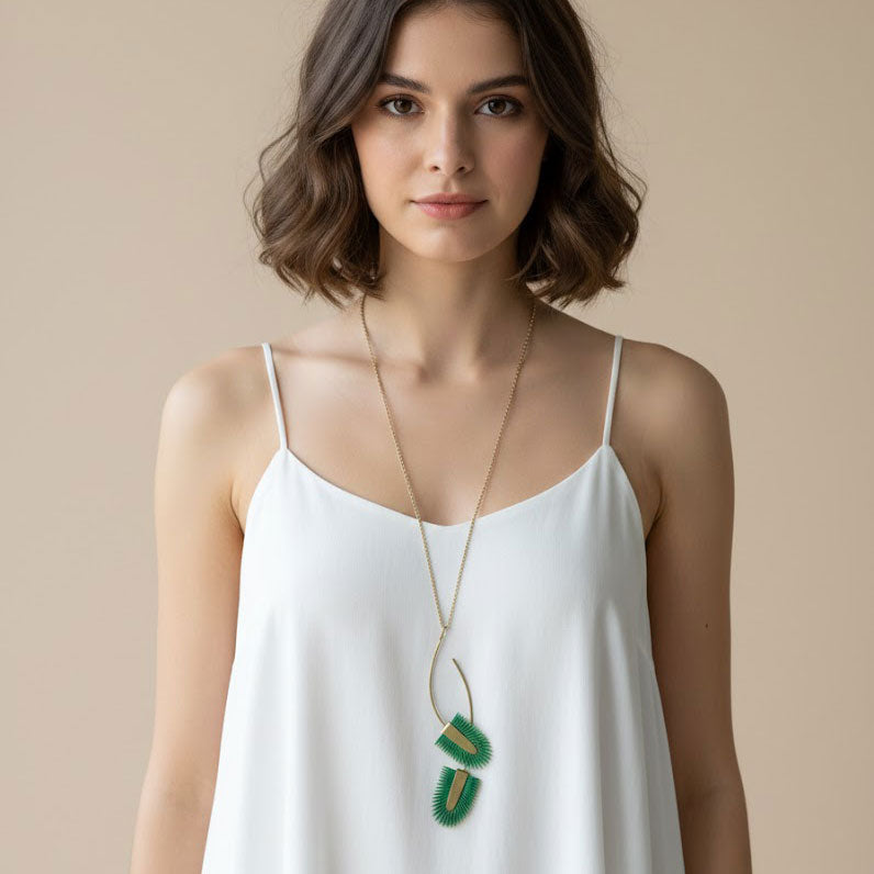 Collar largo artesanal Verde Tropical Doble con dos colgantes de piel pintada en verde esmeralda y latón satinado sobre cadena dorada regulable.