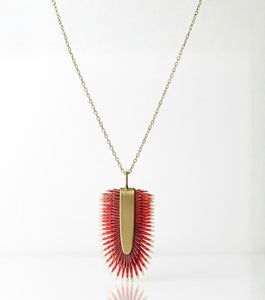 Collar largo artesanal Rojo Tropical con colgante redondo de piel pintada en degradado rojo intenso y blanco, base de latón y cadena dorada larga.