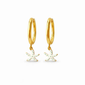 Pendientes aro de acero dorado con estrella de mar blanca con pintitas turquesas puesto en modelo. Pendientes de acero inoxidable Algo de Olga.