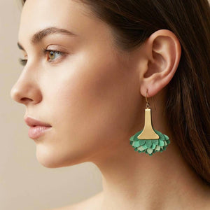 Los pendientes lo lleva puestos la modelo, son unos pendientes artesanales Paraíso Verde de piel pintada en degradado menta y esmeralda con base de latón satinado, hechos a mano.