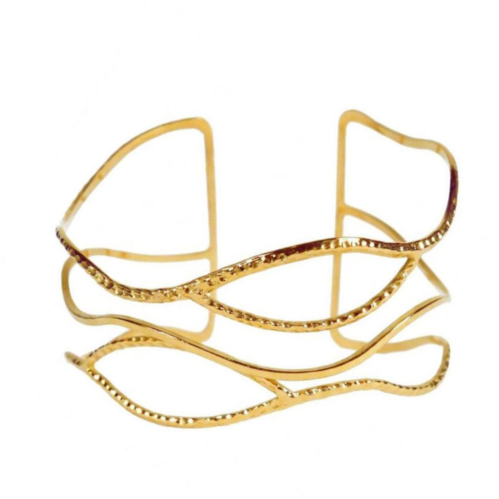 Brazalete dorado abierto ondulado con textura diamantada de acero inoxidable sobre fondo blanco. Pulsera Anuska Algo de Olga.