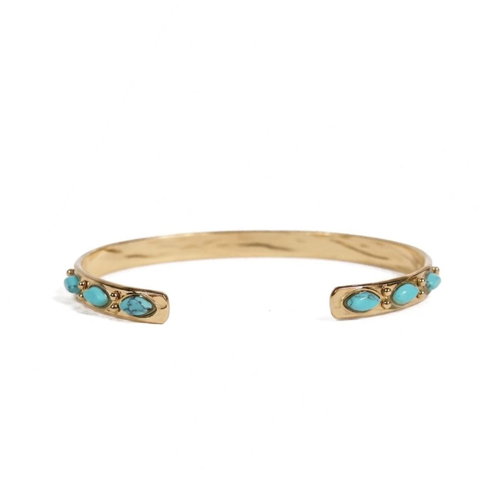 Pulsera Ariadna Turquesa de acero con baño de oro, brazalete abierto con turquesas naturales, sobre fondo blanco. Joyería artesanal española Algo de Olga.