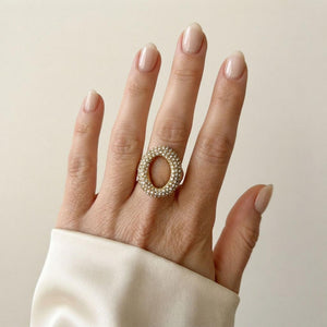 Mano con anillo Moss de acero dorado y cristales blancos, forma asimétrica