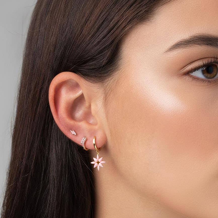 Pendientes de aro con colgante con forma de flor rosa puestos en una modelo, plata de ley bañada en oro