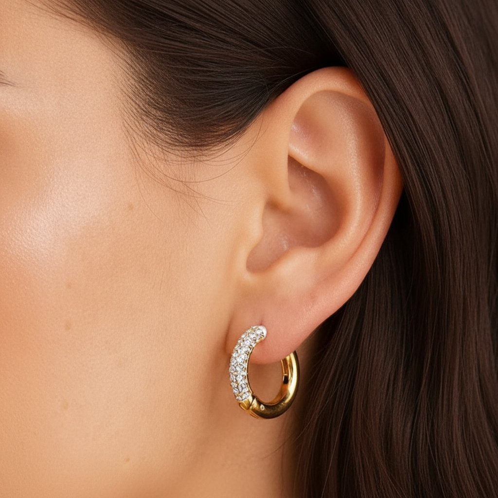 Modelo con pendiente de aro Nicole de acero dorado y cristales blancos