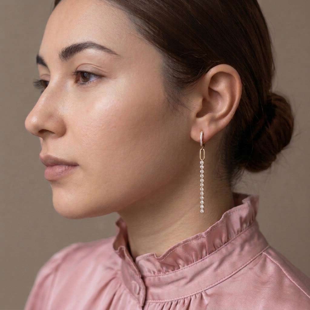 Modelo con moño y pendiente de aro Erin dorado con hilera de circonitas blancas