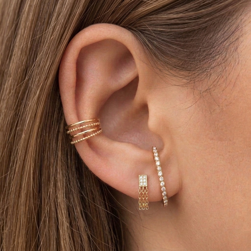 Combinación del pendiente Kaia dorado con circonitas y cadenas, junto a otros pendientes dorados